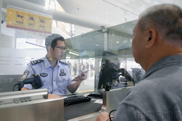白云边检站移民管理警察为旅客办理出境手续(图:黎锋俊)1