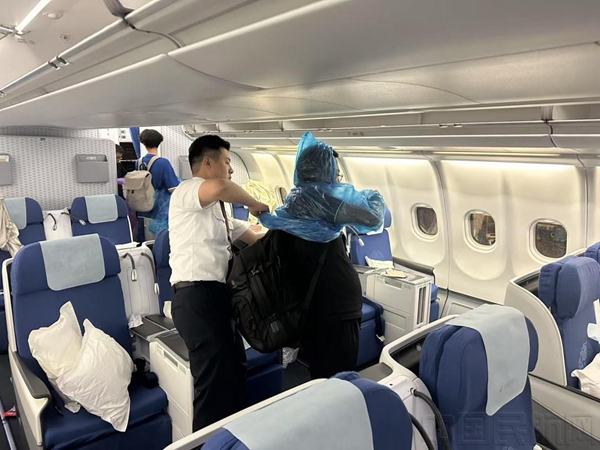乘务组协助下机旅客穿好雨衣-东航供图4