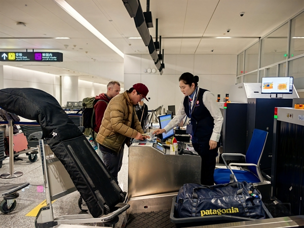 NEO图2南航工作人员为旅客托运雪具。